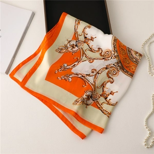 Detail of silk square scarf with gold Baroque patterns and elegant pearl necklace