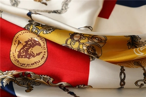 Close-up of luxury silk scarf showing baroque chain patterns and smooth satin texture