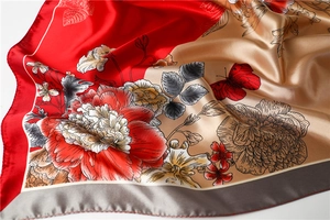 Detail of red and gold satin scarf with peony prints and elegant silk texture