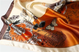 Close-up of a 90cm satin silk scarf with peony flower prints and hand-rolled edges