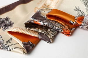 Detailed close-up of premium satin silk scarf with vintage orange peony floral patterns