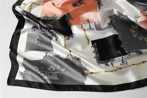 Detailed macro shot of baroque pattern silk scarf showing smooth satin texture and fold