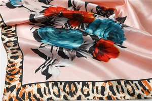 Detailed view of pink satin scarf with red roses and leopard print border texture