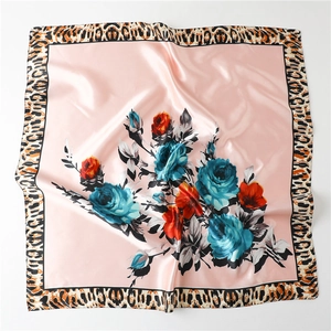 Close-up of satin square scarf with floral rose pattern and leopard print border