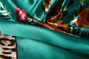 Detail of satin floral scarf with peacock green leopard print and red roses texture