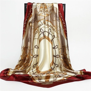 Detail view of burgundy satin scarf with golden chain print and equestrian pattern