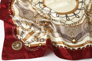 Close-up of satin scarf showing luxury chain patterns and smooth draped fabric texture