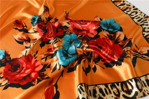 Detailed satin texture of leopard print square scarf with red rose and blue floral patterns
