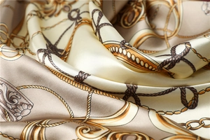 Detail showing high-quality satin scarf with nautical chain patterns and smooth silk texture