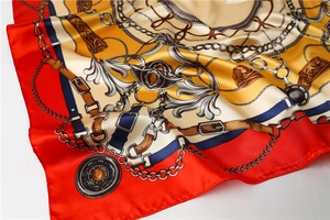 Macro detail of satin square scarf featuring baroque gold chain print and smooth edges
