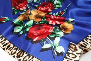 Detail of silk satin scarf with blue roses and leopard print border with soft drape