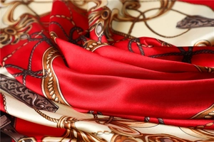 Macro shot of satin scarf featuring vintage chain and harness prints with glossy texture