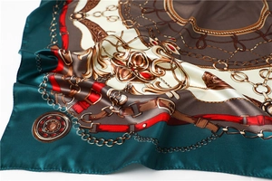Detail of satin scarf showing glossy silk-like texture and vintage gold chain patterns