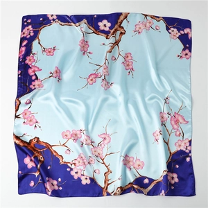 Detailed view of pink plum blossom print on silky large square scarf with blue gradient