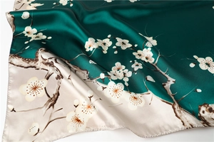 Detailed close-up of plum blossom print on silk scarf with premium rolled hem edges