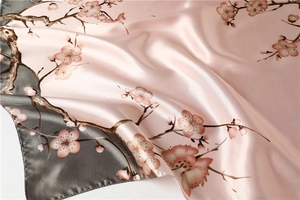 Detailed texture of silk-like scarf with plum blossom print and elegant color blocking