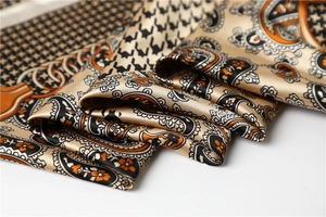 Detail of luxury houndstooth and paisley satin scarf showing smooth silk texture