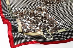 Detail of luxury silk scarf with houndstooth, paisley patterns and equestrian motifs