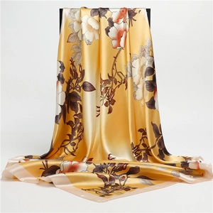 Detailed view of yellow floral silk scarf with elegant botanical print and glossy finish