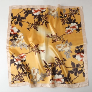 Detail of floral print silk scarf featuring ginger gradient satin fabric and elegant folds