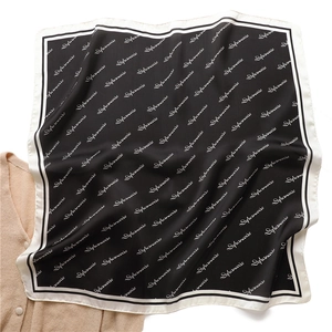 Elegant black silk square scarf with white letter print and satin finish on knitwear