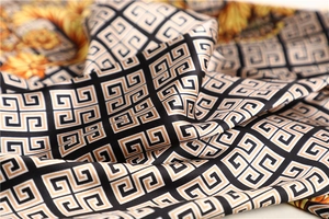 Detail of silk satin scarf showing geometric Greek patterns and sunflower floral print