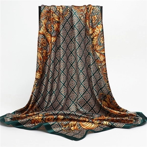 Detailed view of dark green satin scarf with golden Baroque patterns and smooth texture