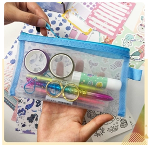 Close-up of a blue mesh zipper pouch filled with colorful pens and stickers