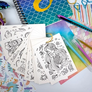 Detailed view of mermaid-themed coloring cards with a gold metal binder ring for kids