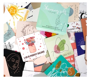 Macro detail of 'Shining Self' affirmation cards and branded packaging box in stacks