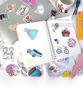 Close-up of wedding cartoon stickers on a laptop and notebook for DIY party planning