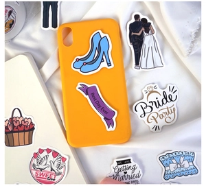 Detailed view of wedding stickers on a phone case and notebook with romantic motifs