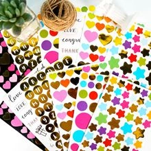 Macro shot of colorful inspirational text stickers with gold foil hearts and stars