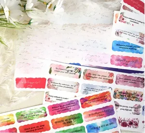 Close-up of watercolor inspirational stickers with scalloped edges on white lace background