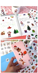 Detailansicht von Weihnachtsaufklebern auf Laptop und Handyhülle für DIY-Feiertagsdeko