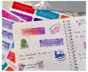 Detailed view of inspirational quote stickers and cute cartoon animal shapes on a notebook