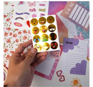 Close-up of golden foil emoji stickers featuring shiny metallic smiley faces