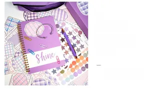 Detailed view of purple DIY journal set with notebook, stickers, and stationery items