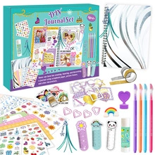 Flat lay of colorful DIY journal kit with spiral notebook, stickers, and pens for kids