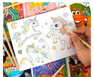 Gros plan d'un enfant coloriant un livre de licorne avec des crayons en bois