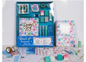 Flat lay of DIY journal set with notebook, glitter tape, stickers and art supplies