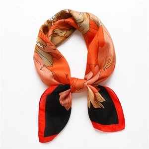 Détail du foulard carré en soie avec imprimé pivoine et bords roulés rouges noués