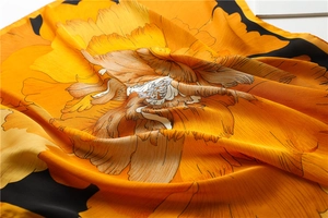 Vue détaillée d'un foulard carré en soie avec motifs de pivoines et fini satiné