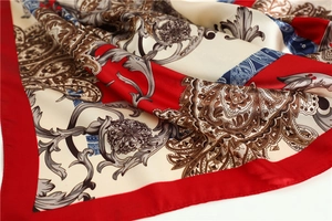 Detailed close-up of red paisley pattern silk scarf showing soft fabric texture and drapes