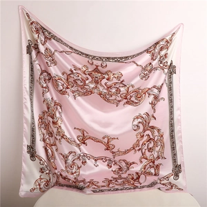 Detail of pink baroque silk scarf showing elegant swirl patterns and glossy fabric drape