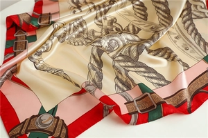 Detail view of large silk scarf featuring vintage patterns and elegant satin texture