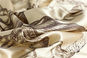 Detailed close-up of champagne satin scarf featuring vintage equestrian rope patterns