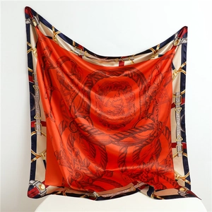 Detail of vibrant orange silk-satin scarf featuring elegant equestrian stirrup patterns