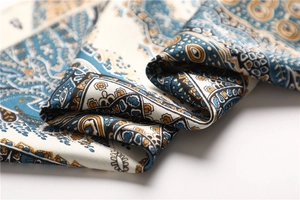 Detailed macro shot of vintage paisley patterns on a soft satin finish square scarf