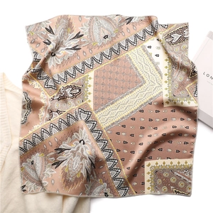 Detailed flat lay of paisley print silk scarf in coffee and ginger tones on knitwear